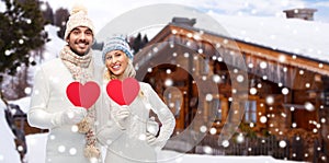 Happy couple in winter clothes with heart outdoors