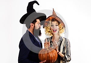 Happy couple in witches hats with pumpkin. Young people dressed at Halloween. Celebration and party. 31 october.