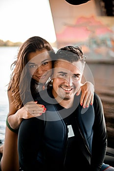 Happy couple of young woman and man in swimsuits on blurred background