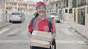Happy courier girl with thermal backpack holding packages