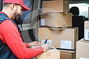 Happy courier man signing package delivery in van truck - Focus on face