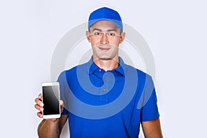 Happy courier with phone. looking at camera. isolated gray background. Studio shoot