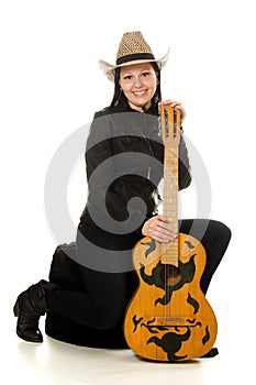 Happy cowgirl in ahat with acoustic guitar