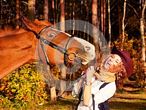 Happy cowgirl with her red horse.