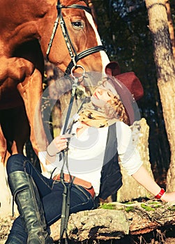 Happy cowgirl with her red horse.