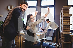 Happy coworkers enjoying by desk in creative office