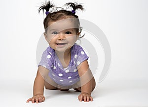 Happy, crawling baby in purple onesie