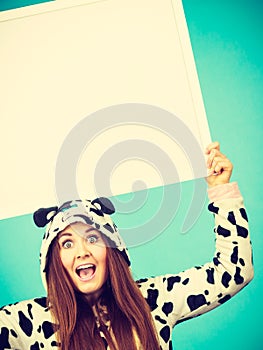 Happy crazy woman in cow costume holding board