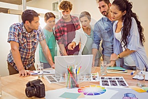 Happy creative business team using laptop in meeting