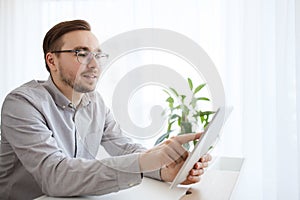Happy creative male office worker with tablet pc