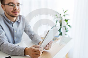 Happy creative male office worker with tablet pc