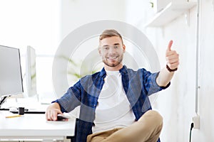 Happy creative man with computer at office