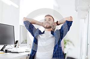 Happy creative man with computer at office
