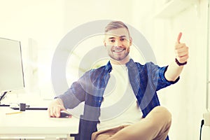 Happy creative man with computer at office