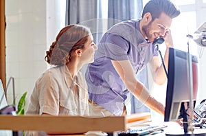 Happy creative team calling on phone in office