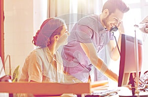 Happy creative team calling on phone in office