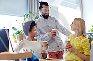 Happy creative team drinking coffee in office