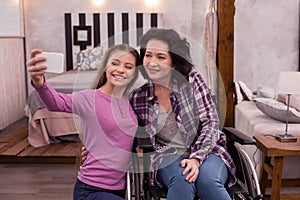 Happy crippled woman and girl taking photo