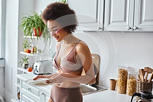 happy and curly african american woman