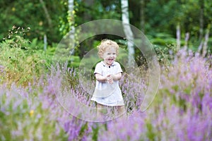 Happy curly baby girl laughing in heathland