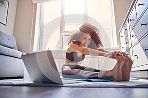 Happy curly haired girl doing stretching exercises