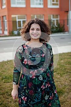 Happy curvy girl with curly hair in the street