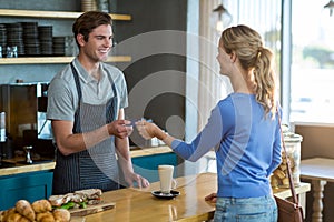 Happy customer giving credit card to waiter