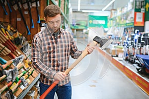 happy customer in a hardware store buying a new ax