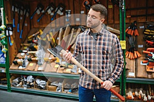 happy customer in a hardware store buying a new ax
