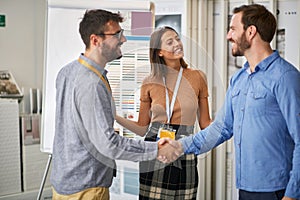 Happy customer with salesman in store for household