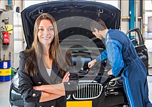 Happy customer, waiting for a mechanic to fix her car