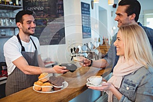 Happy customers paying through card at cafe