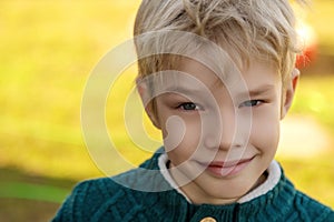 Happy cute baby boy child is smiling enjoying adopted life. Portrait of young boy in nature, park or outdoors photo