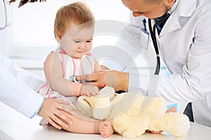 Happy cute baby at health exam at doctor`s office. Medicine and health care concept