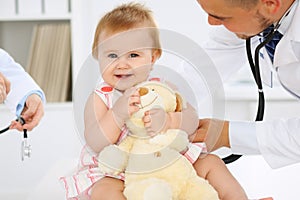 Happy cute baby at health exam at doctor`s office. Medicine and health care concept