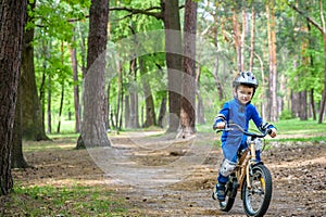 Happy cute blond kid boy having fun his first bike on sunny summer day, outdoors. child making sports. Active leisure for