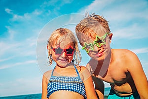 Happy cute boy and girl play with water on beach