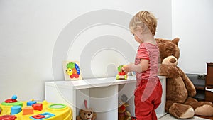 Happy cute child boy having fun playing with colorful wooden toys, at home. Indoor activity for kids