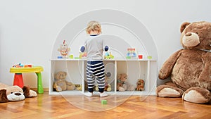 Happy cute child boy having fun playing with colorful wooden toys, at home. Indoor activity for kids