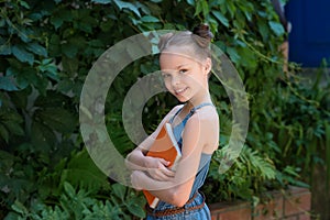 Happy cute child girl in school uniform holding books