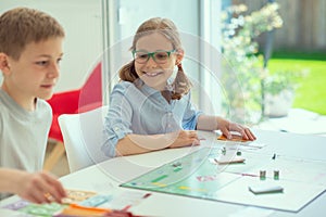 Happy cute children playing board games and having fun at home