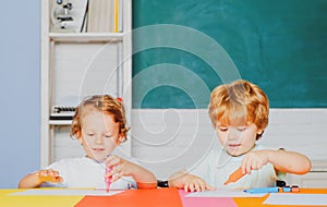 Happy cute clever boys pupils drawing. Kids funny education. Preschool childrenhaving fun in classroom. Kids ready for