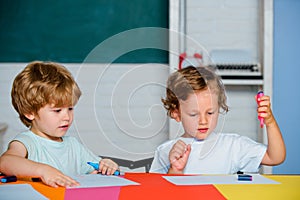 Happy cute clever boys pupils drawing. Kids funny education. Preschool childrenhaving fun. Kids ready for school.