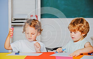 Happy cute clever boys pupils drawing. Kids funny education. Preschool childrenhaving fun. Kids ready for school.