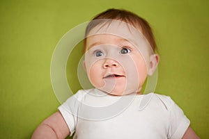 Happy, cute and closeup of baby in studio playing for child development and curious face. Smile, sweet and zoom of young