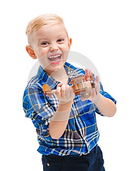 Happy cute baby boy playing with a toy airplane and laughing cheerfully. Isolated on white.
