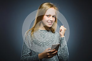 Happy cute girl with cell phone. isolated on gray