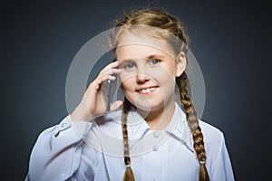 Happy cute girl with cell phone. isolated on gray