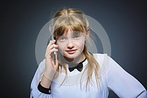 Happy cute girl with cell phone. isolated on gray