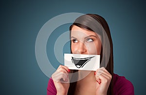 Happy cute girl holding paper with funny smiley drawing